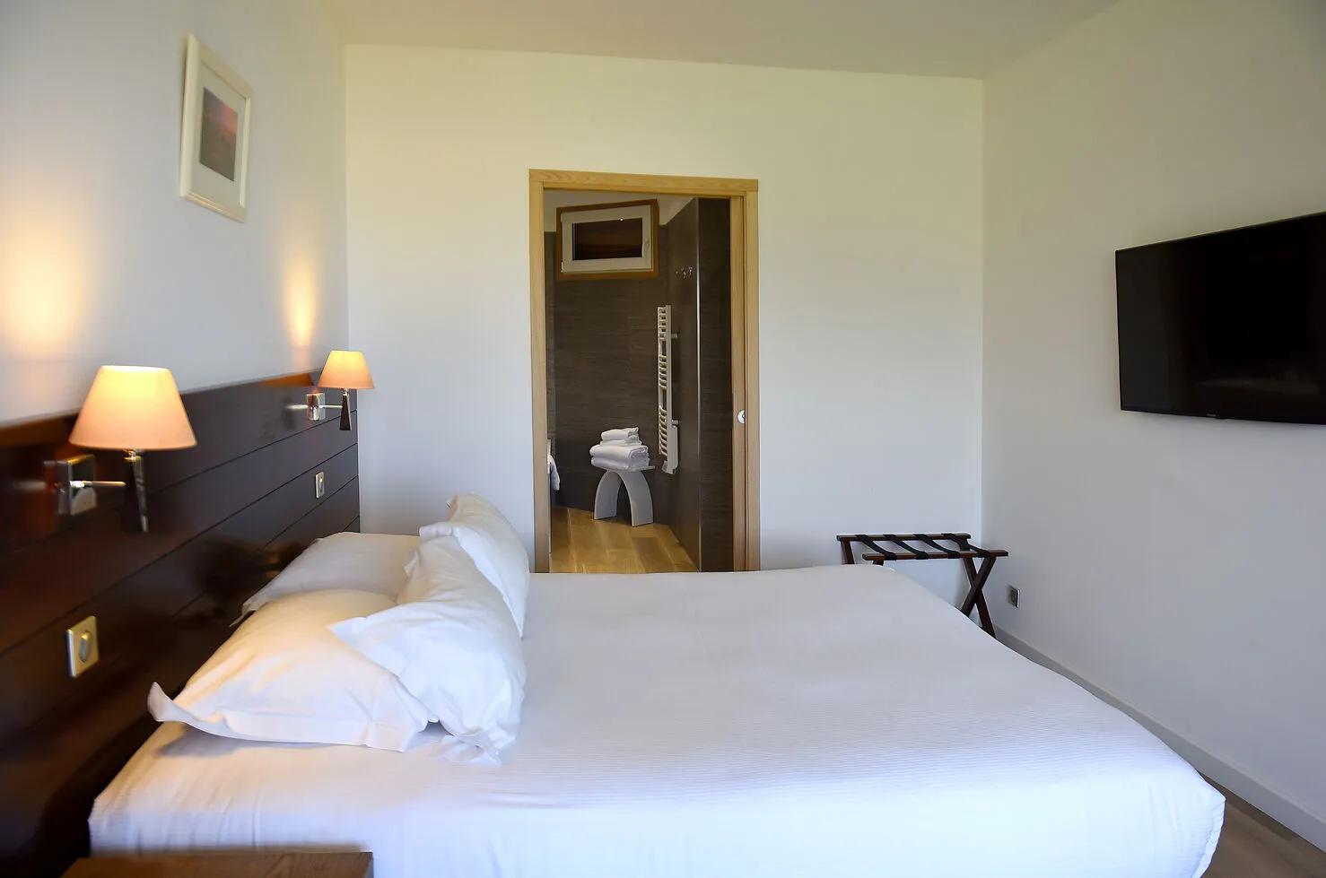 Lit confortable dans les suites de l'hôtel La Roya à Sant-Florent
